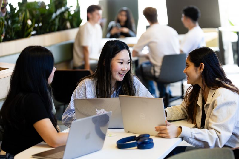 Students with laptops talking