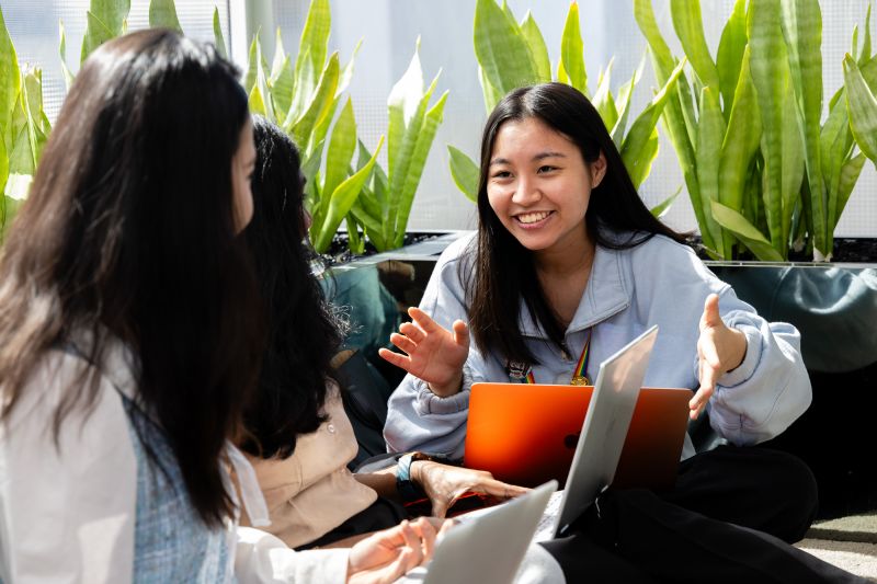 Students talking over laptop
